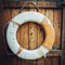 Vintage Lifebuoy Hanging On A Rustic Wooden Wall With Copy Space