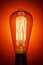 Vintage light bulb, on bright red background. Abstract composition. Old style
