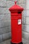Vintage London post box in red against a gray wall