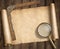 Vintage loupe on table with treasure map scroll and ruler