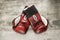 Vintage maroon leather boxing gloves on a grunge background