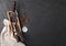 Vintage meat knife and fork and hatchet in old wooden box on black table background. Butcher utensils. Space for text