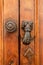 Vintage metal doorknob, knocker gong on a wooden door