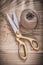 Vintage metal golden scissors hank of rope on wooden board