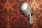 Vintage metal microphone on wallpaper background