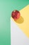 Vintage minimal geometric concept with red Christmas bauble on white, yellow and mint green background. Creative gravity