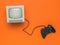 Vintage monitor and game console with a wire on an orange background
