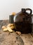 Vintage moonshine jug on a rustic wooden table with potatoes and corn cob cork
