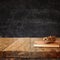 Vintage notebook and stack of wooden colorful pencils on wooden textures table against chalkboard background