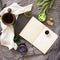 Vintage notebook surrounded by herbs, alchemy appliances, potions and ingredients lies on natural slate slab wooden table.