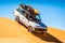 Vintage off road car driving of the sand dune in Merzouga, Erg Chebbi in Morocco