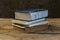 Vintage old books on wooden deck table with soil wall