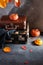 Vintage old fashioned Suitcases with pumpkins and autumn leaves on dark background. Travel agency, antique store concept. Copy