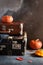 Vintage old fashioned Suitcases with pumpkins and autumn leaves on dark background. Travel agency, antique store concept. Copy