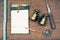 Vintage old notebook, binoculars, compass, knife, rope on wooden table background