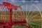 A vintage old red farm plow on a field at Sandstone Estates