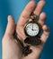 Vintage old watch on a chain. hand holding a watch on a chain.