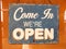 Vintage open sign board word `Come in We`re Open`