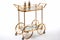 Vintage Opulence: Gold Bar Cart with Mirrored Shelves on White Background