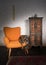 Vintage orange armchair, ornamented cupboard, black scarf and re