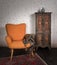 Vintage orange armchair, ornamented cupboard, black scarf and red carpet