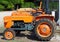 Vintage orange tractors from  Sixties lined up in a gravel road