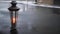 Vintage ornate lantern on wet city pavement with snow falling - christmas spirit concept