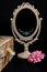 Vintage Oval Desk Mirror with white frame, rose and a vintage box on black background