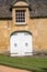 Vintage painted white wooden double door with stones frame and strap hinges.