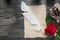 Vintage paper feather red rose present box on wooden board holid