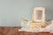 Vintage pearls , antique wooden jewelry box with mirror and perfume bottle on wooden table. filtered image