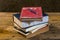 Vintage pencil and old books on wooden deck table with soil wall