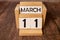 Vintage photo, March 11th. Date of 11 March on wooden cube calendar, copy space for text on board