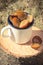 Vintage photo, Plums in metallic mug on wooden stump in garden on sunny day