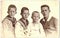 Vintage photo shows the group of four boys (siblings). Some boys wear sailor costume. Black and white portrait. Circa