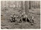 Vintage photo shows soldiers pose with beer bottles outdoors. Black and white antique photo.