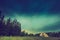 Vintage photo of storm sky over meadow, house and forest