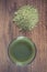 Vintage photo, Young powder barley with cup of beverage on wooden background