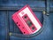 Vintage pink audio cassette in pocket jeans. Retro music technology concept