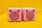 Vintage pink radio speakers on yellow background, musical concept