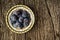 Vintage plate of plums. Rustic wooden background. Close up. Flat lay