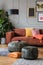 Vintage poufs in trendy eclectic living room interior with brown couch
