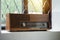 Vintage radio receiver - antique wooden box radio on windowsill against sunrise from outside , retro technology