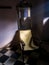 A vintage reclining chair made of wood and straw below a mirror in a dark room in