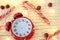 Vintage red alarm clock on white background. alarm clock shows five to midnight. Christmas sweets, garlands and alarm clock on a w