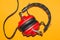 Vintage red headphones on yellow background. classic earphones