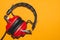 Vintage red headphones on yellow background. classic earphones