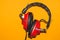 Vintage red headphones on yellow background. classic earphones