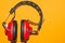 Vintage red headphones on yellow background. classic earphones