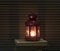 Vintage red lantern on old books. Candle burning